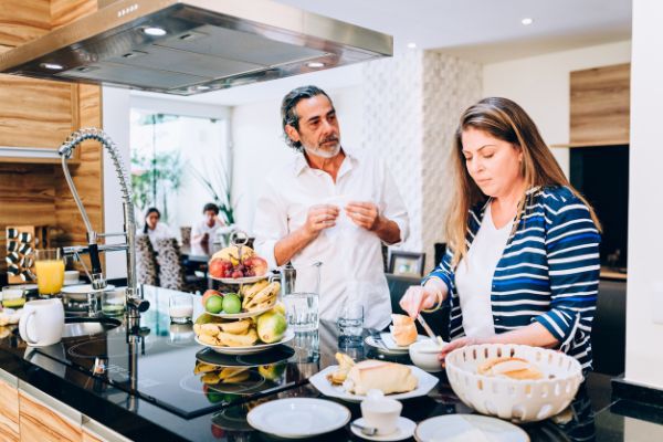 Husband and wife cooking in kitchen