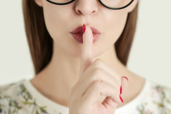 finger to lips representing silence